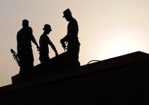 A silhouette of three workers
